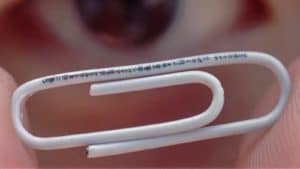 close-up photo of white paperclip being held between two human fingers